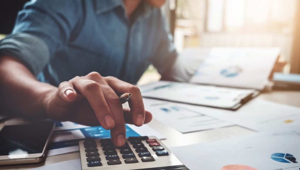 Business accounting concept, Business man using calculator with computer laptop, budget and loan paper in office.