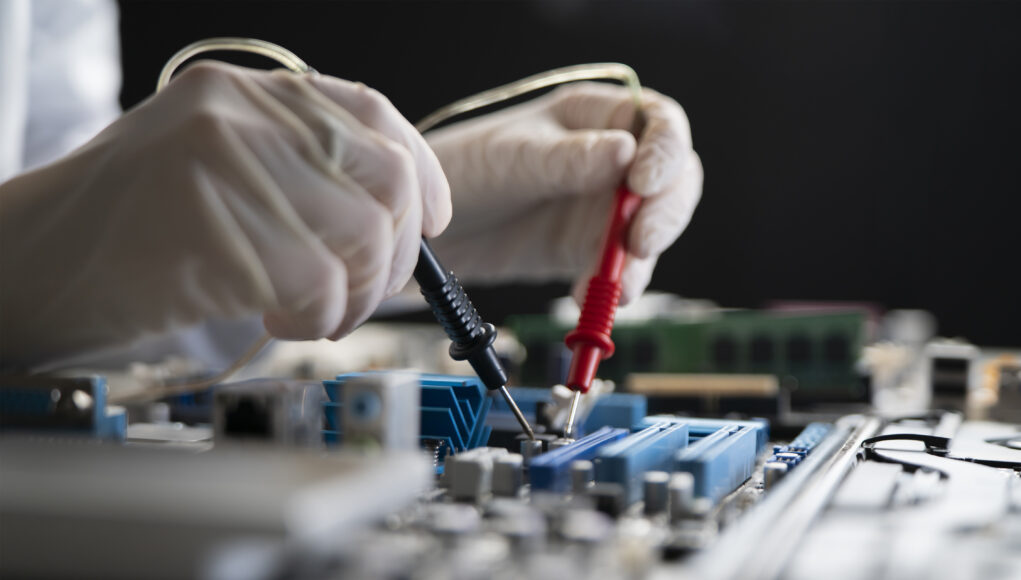 a person holding multimeter tool and making measurement on pcb computer board